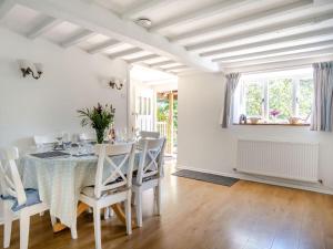 a white dining room with a table and chairs at Lisle Combe Cottage in Ventnor