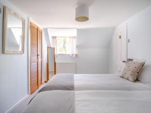 a bedroom with a white bed and a window at Lisle Combe Cottage in Ventnor