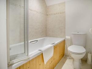a bathroom with a bath tub and a toilet at Lisle Combe Cottage in Ventnor +41 photos