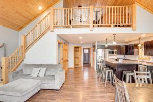 イーグル・リバーにあるBoat Dock and Furnished Deck Northwoods Lake Houseのソファとテーブルのあるリビングルームとキッチン