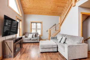 イーグル・リバーにあるBoat Dock and Furnished Deck Northwoods Lake Houseのソファとテレビのあるリビングルーム