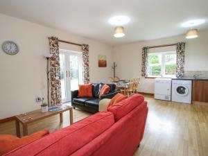 un soggiorno con un divano rosso e un tavolo di Cooinda Cottage a Morar