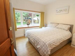 una camera da letto con un letto e una finestra di Cooinda Cottage a Morar
