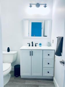 un bagno bianco con lavandino e WC di BEACH BLOCK TOWNHOME - Casinos, Shopping, Fun! a Brigantine Altre 31 foto