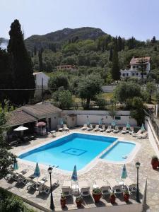 a large swimming pool with chairs and a resort at Elli Marina Studios & Apts Benitses Mare in Benitses