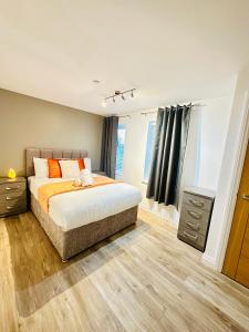 a bedroom with a bed with orange and white pillows at 2 Beds Mint drive With Secure car Or Van Park w WiFi-Netflix No Deposit Required in Birmingham