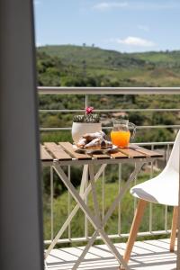 a table with a plate of food and orange juice on a balcony at B&B Bdieci in Valguarnera Caropepe +18 photos