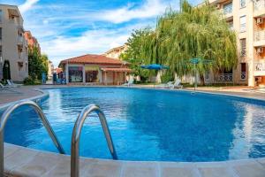 ein großes blaues Schwimmbecken mit zwei Gebäuden in der Unterkunft Double Cherry Apartment in Sonnenstrand