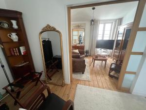 a living room with a mirror and a couch at Le Logis des Templiers Vieux Port in La Rochelle