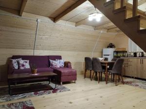 a living room with a purple couch and a table at Guesthouse Venera in Mestia