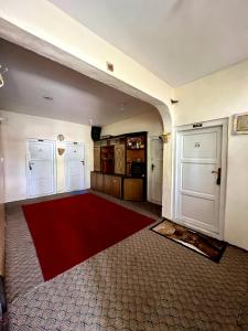 een kamer met een rood tapijt en twee witte deuren bij Dream Guest House, Skardu in Skardu