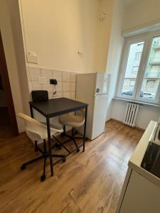 a kitchen with a table and two chairs and a refrigerator at Gorizia Living in Turin