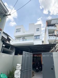 a white building with a gate in front of it at Urbanest Saigon in Ho Chi Minh City