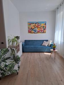 科莫Casa Andrea Lake Como的客厅里有一张蓝色的沙发和一张桌子