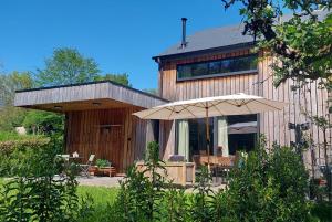 een houten huis met een paraplu ervoor bij Chez Rosé in Sainte-Cécile