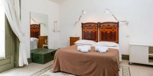 una camera da letto con un letto grande con due cuscini di La Moresca Hotel a Marina di Ragusa