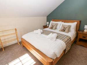 Un dormitorio con una cama grande con toallas. en The Coach House at Mayfurlong Farm, en Leek