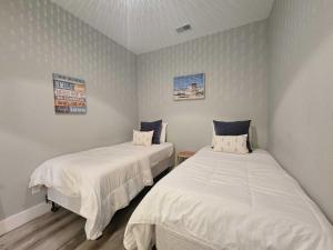 two beds in a room with white sheets at Cozy TC Bay Condo in Traverse City