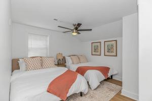 une chambre avec deux lits et un ventilateur de plafond dans l'établissement Beachside 5BR 5BTH Bungalow, 1 Block from Ocean, à Myrtle Beach
