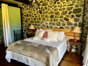 En eller flere senge i et værelse på Fazenda Caminho do Ouro