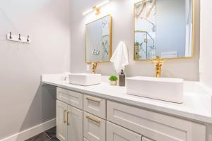 a bathroom with two sinks and two mirrors at Eagle Retreat Mountain Getaway in Whittier