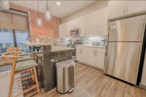 Una cocina con refrigerador de acero inoxidable y una mesa. en Chic Modern 2 bed Apartment with Exposed Brick, en Boston