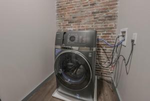 Una lavadora en una habitación con una pared de ladrillos. en Chic Modern 2 bed Apartment with Exposed Brick, en Boston 4 fotos más