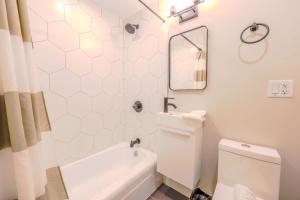 Un baño blanco con inodoro y lavabo. en Peaceful South End Studio, en Boston