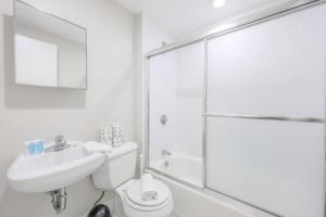 Un baño blanco con inodoro y ducha. en Quaint Studio Apt Steps from Back Bay, en Boston