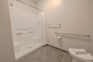 Un baño blanco con ducha y WC. en Simple Spacious Apartment, en Boston