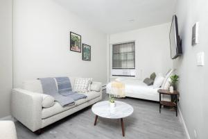 a white living room with a couch and a table at Charming South End Studio Apt in Boston