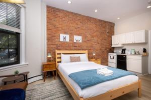 ein Schlafzimmer mit einem Bett und einer Ziegelwand in der Unterkunft Serene Studio with Cozy Atmosphere in Boston