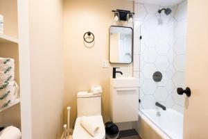 een kleine badkamer met een toilet en een spiegel bij Bright Modern Studio in the South End in Boston