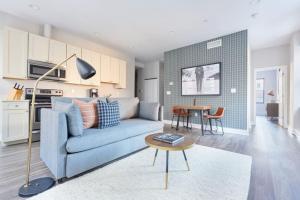 a living room with a blue couch and a table at Bright FIDI 1 Bedroom Centrally Located in Boston