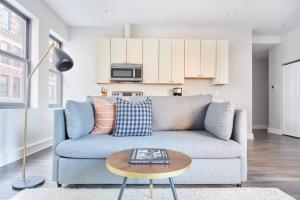 a living room with a blue couch and a table at Bright FIDI 1 Bedroom Centrally Located in Boston