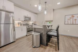 a kitchen with white cabinets and a stainless steel refrigerator at Charming 1 Bedroom Apt Laundry in Unit in Boston
