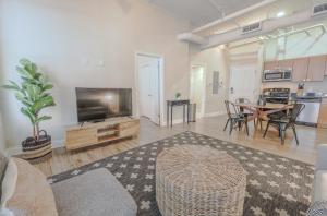 a living room with a television and a table with chairs at Airy 2BR in Fidi Boston Walk anywhere in Boston
