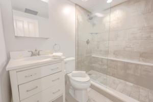 a white bathroom with a toilet and a shower at Boston Financial District 1BR Walk to anything in Boston +7 photos