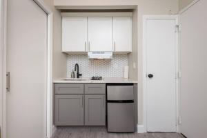 a kitchen with white cabinets and a sink at Lovely South End Studio in Boston