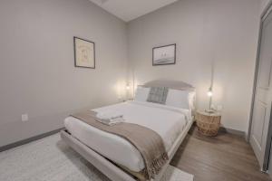 a white bedroom with a large bed and a table at Elegant 2 Bedroom Prime Location in Boston