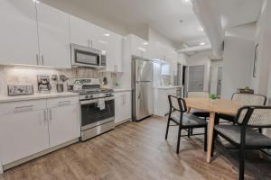 eine Küche mit weißen Schränken und einem Tisch und Stühlen in der Unterkunft Stylish Downtown 2 Bedroom in Boston