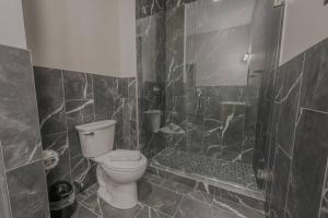 ein Bad mit einem WC und einer ebenerdigen Dusche in der Unterkunft Stylish Downtown 2 Bedroom in Boston