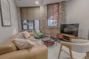 ein Wohnzimmer mit Sofa und Fernseher in der Unterkunft Stylish Downtown 2 Bedroom in Boston