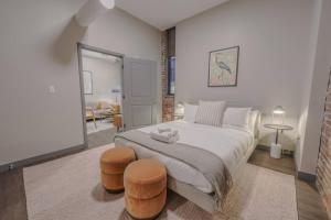 ein Schlafzimmer mit einem großen Bett mit zwei Hockern in der Unterkunft Stylish Downtown 2 Bedroom in Boston