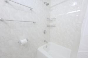 ボストンにあるChic 1 Bed Apartment Steps from Boston Commonのトイレとシャワー付きの白いバスルーム