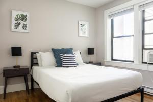 een slaapkamer met een groot wit bed en een raam bij 1 Bedroom in Heart of Theater District Walk Anywhere in Boston