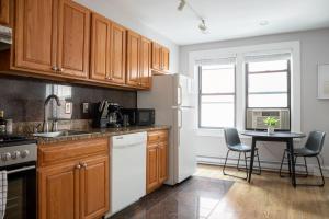 een keuken met houten kasten en een tafel met stoelen bij 1 Bedroom in Heart of Theater District Walk Anywhere in Boston