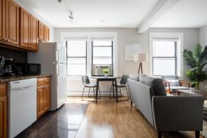 een keuken en woonkamer met een tafel en stoelen bij 1 Bedroom in Heart of Theater District Walk Anywhere in Boston