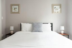 ein Schlafzimmer mit einem großen weißen Bett mit zwei Lampen in der Unterkunft Simple 1BR steps to Boston Common and South End in Boston