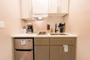 a small kitchen with white cabinets and a sink at Bold and Spacious Studio Back Bay in Boston